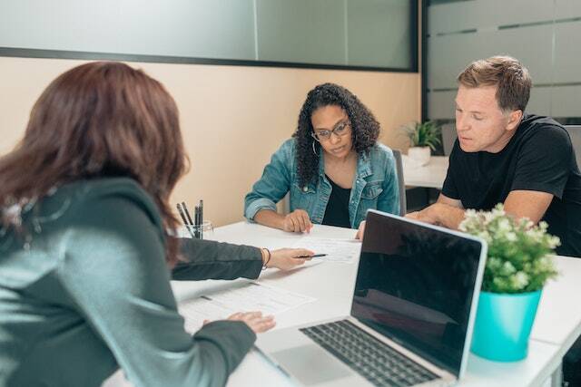 landlord showing to tenants a lease contract while sitting at desk